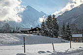 Farmhouse in snowy winter landscape in front of mountain panorama, Germany, Bavaria, Oberallgäu, Oberstdorf