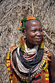 Ethiopia; Southern Nations Region; Kolcho village; on the Omo River; Omo Valley; Woman from the ethnic group of the Karo; dressed in a typical leather apron; Head and neck jewelry made from multicolored pearl necklaces