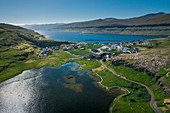 Dorf Eidi auf Eysturoy der Färöer Inseln bei Sonne am Tag von oben\n