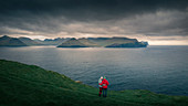 Couple on Kalsoy looking towards Eysteroy in sunset, Faroe Islands