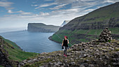 Frau beim Wandern auf Streymoy auf Färöer Inseln bei Tag\n