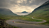 Mann auf der kurvigen Straße nach Norðradalur auf Streymoy, Färöer Inseln\n