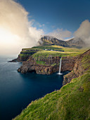 Wasserfall Múlafossur mit Dorf Gásadalur auf der Insel Vagar, Färöer Inseln\n