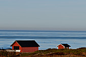 Rote Fischerhütten und ein Boot am Meer bei Grimsholmen, Hallandslän, Schweden