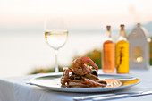 Garnelen mit Weißwein bei Sonnenuntergang in einem Restaurant in Pefkos, Rhodos, Dodekanes, griechischen Inseln, Griechenland, Europa