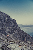 Frau steht in den Bergen im Rätikon über dem Lünersee, Vorarlberg, Österreich, Europa