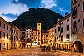 Evening view of Piazza Flaminio in the Serravalle district in Vittorio Veneto, in the background the Civic Tower and the Community Palace. Veneto region. Italy