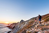 Frankreich, Finistère, Plogoff, Wanderer bei Sonnenuntergang bei Pointe du Raz