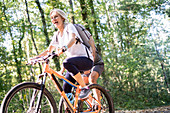 Niedrige Winkelansicht des reifen Paares, das Fahrräder im Wald reitet