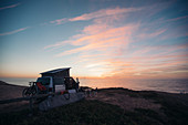 Campingbus steht an Meeresküste beim Sonnenaufgang,  Portugal