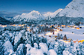Winterwald bedeckt mit Schnee, der Chiesa Bianca und Maloja in der Abenddämmerung, Bregaglia, Engadin, Kanton Graubunden, Schweiz, Europa umgibt