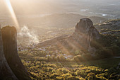 Sonnenuntergangslicht und Sonnenstrahlen im Rauch in Meteora, Thessalien, Griechenland, Europa
