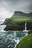 Denmark,Faroe Islands,Gasadalur Village,M?Lafossur Waterfall,Coastline with Mulafossur Waterfall falling into Atlantic Ocean