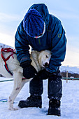 Cuddling with the dogs after a dog sledding tour at Indset, Björn Klauer's husky farm, Bardufoss, Norway