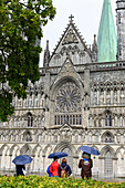 People with umbrella in front of Nidaros Cathedral west facade, Trondheim, Norway