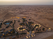 Luftaufnahme vom Arabian Nights Village Wüstenresort inmitten von Dünen bei Sonnenuntergang, Arabian Nights Village, Razeen Area von Al Khatim, Abu Dhabi, Vereinigte Arabische Emirate, Naher Osten