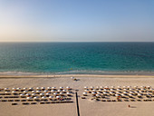 Luftaufnahme von Liegestühlen und Sonnenschirmen der Hotelanlage Saadiyat Rotana Resort & Villas mit Meer dahinter, Saadiyat Island, Abu Dhabi, Vereinigte Arabische Emirate, Naher Osten