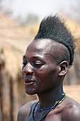 Angola; westlicher Teil der Provinz Cunene; junger Mann aus der Volksgruppe der Mucohona; mit Irokesenfrisur