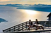 Zwei junge Frauen auf Terrasse, Vom Fagernesfjell hat man einen tollen Blick auf den Ofotfjord und, Narvik, Norwegen