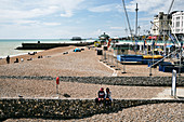 Brighton Beach mit Blick auf die verbrannten Überreste von West Pier, Brighton, East Sussex, UK