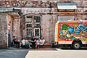 Belarussian youth lounging in the hipster district of Leninsky next to a food truck in Minsk Belarus.