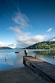 View over Lake Millstatt from the beach on the east bank of the alpine mountain and cultural landscape, Döbriach, Carinthia; Austria, Europe.