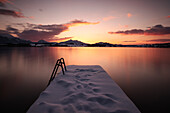 View of the sunset at the Hopfensee, in the foreground a snow-covered footbridge Bavaria, Germany, Europe