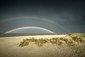 Sanddünen an der Nordsee unter Sturmwolken mit Regenbogen, Schillig, Wangerland, Friesland, Niedersachsen, Deutschland, Europa