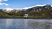 Campers crossing a river in the highlands of Iceland