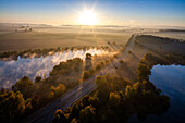 Morgenlandschaft mit Seen an der A7 bei Hildesheim, Gegenlicht, Luftaufnahme, Sonne am Horizont, Deutsche Autobahn