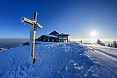 Verschneites Gipfelkreuz und Hochrieshütte am Gipfel der Hochries, Hochries, Chiemgauer Alpen, Oberbayern, Bayern, Deutschland