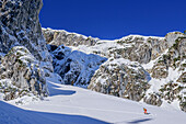 Frau auf Skitour steigt durch großes Felskar auf, Zwiesel, Chiemgauer Alpen, Oberbayern, Bayern, Deutschland