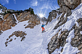Woman on ski tour descends through steep gully from Predigtstuhl, Alpgartenrinne, Predigtstuhl, Lattengebirge, Berchtesgaden Alps, Upper Bavaria, Bavaria, Germany