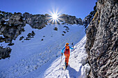 Woman on ski tour climbs up through steep gully to Predigtstuhl, Alpgartenrinne, Predigtstuhl, Lattengebirge, Berchtesgaden Alps, Upper Bavaria, Bavaria, Germany