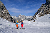Zwei Frauen auf Skitour steigen durch weites Kar auf, Reiteralm im Hintergrund, Ofental, Berchtesgadener Alpen, Nationalpark Berchtesgaden, Oberbayern, Bayern, Deutschland