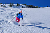 Woman on ski tour descends through powder snow slope, Großer Traithen, Mangfall Mountains, Bavarian Alps, Upper Bavaria, Bavaria, Germany