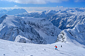 Frau auf Skitour steigt zum Hohen Göll auf, Tennengebirge und Hochkönig im Hintergrund, Hoher Göll, Berchtesgadener Alpen, Nationalpark Berchtesgaden, Oberbayern, Bayern, Deutschland