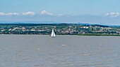 Sailing ship on Lake Neusiedl with the free town of Rust in the background in Burgenland, Austria