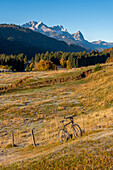 Mountain bike stands on meadow with hoar frost, behind it the Zugspitze, Klais, Werdenfelser Land, Bavaria, Germany