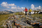 Man and woman hiking on Königstuhl, lichen-covered rocks in the foreground, Königstuhl, Nockberge, Nockberge-Trail, UNESCO Nockberge Biosphere Park, Gurktal Alps, Carinthia, Austria