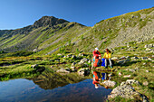 Mann und Frau beim Wandern machen am Rosaninsee Pause, Rosaninsee, Königstuhl, Nockberge, Nockberge-Trail, UNESCO Biosphärenpark Nockberge, Gurktaler Alpen, Kärnten, Österreich