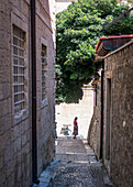 Woman walks through the alleys of the old town of Dubrovnik, Dalmatia, Croatia.