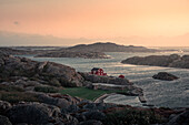 Red hut on the coast at Skärhamn on the archipelago island of Tjörn on the west coast of Sweden in sunset