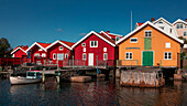 Bunte Bootshäuser an der Westküste von Schweden, Sonne am Tag mit blauem Himmel\n