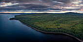 Wald und Seeufer am Siljansee von oben im Sonnenuntergang mit Wolken in Dalarna, Schweden\n