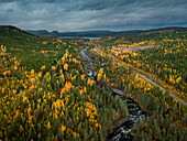 Fluss durch Herbstwald in Jämtland in Schweden, entlang der Wilderness Road, von oben\n
