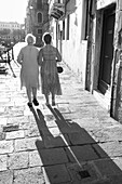 Elderly women walking arm in arm, back view in Venice, Venezia, Veneto, Italy, Europe