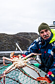 Mann hält eine Königskrabbe in der Hand, Exkursion Königskrabben, Hurtigrute, Snowhotel Kirkenes, Kongekrabbe, King Crab, Kirkenes, Finnmark, Norwegen