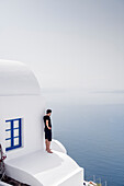 Mann telefoniert auf Häuserdach, Oia, Santorini, Santorin, Kykladen, Ägäisches Meer, Mittelmeer, Griechenland, Europa