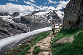Woman hikes on path on Morteratsch Glacier in the Engadin in the Swiss Alps in summer